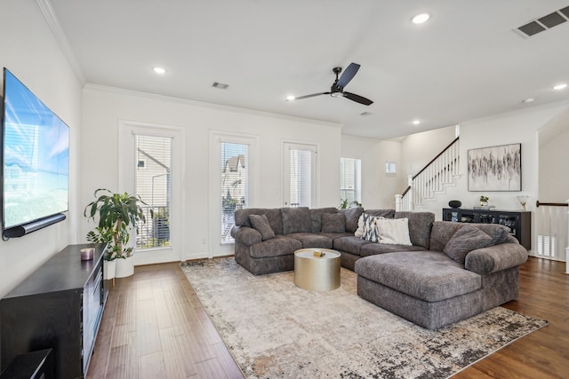 living room with ornamental molding, ceiling fan, and dark wood-type flooring