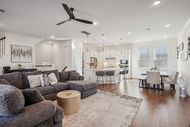 living room featuring ornamental molding, ceiling fan, dark wood-type flooring, and sink