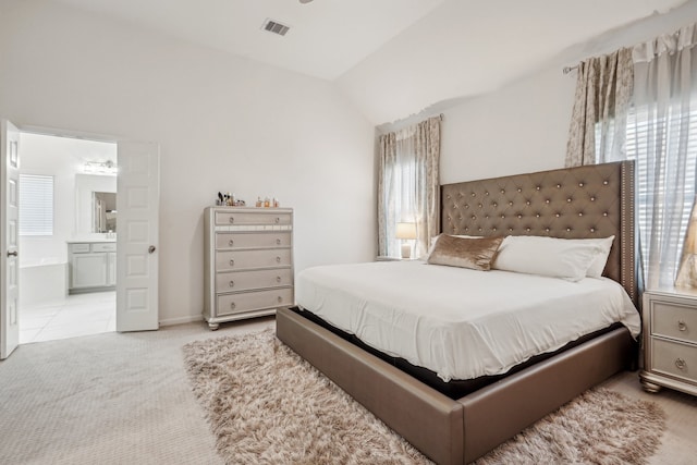 carpeted bedroom featuring connected bathroom, multiple windows, and vaulted ceiling