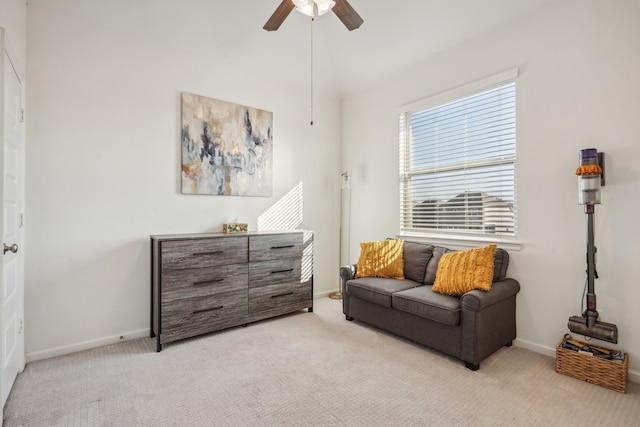 living area with light carpet and ceiling fan