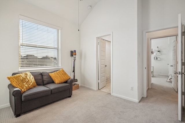 carpeted living room with high vaulted ceiling