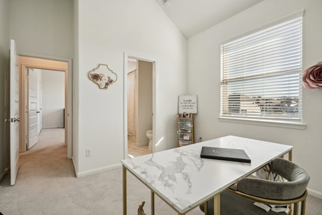 office area featuring light carpet and lofted ceiling