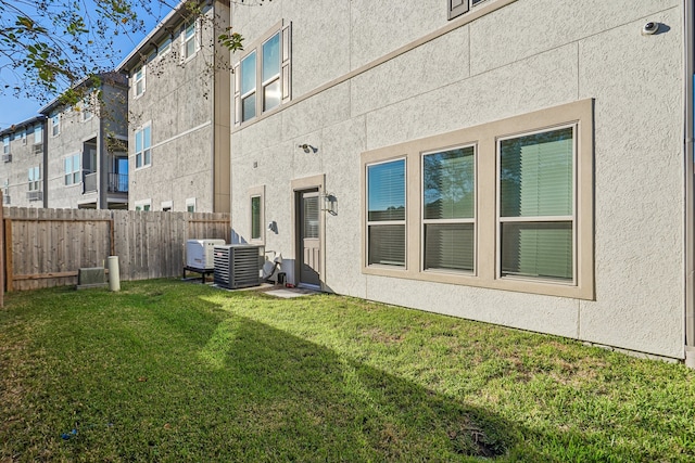 back of property with a lawn and central air condition unit