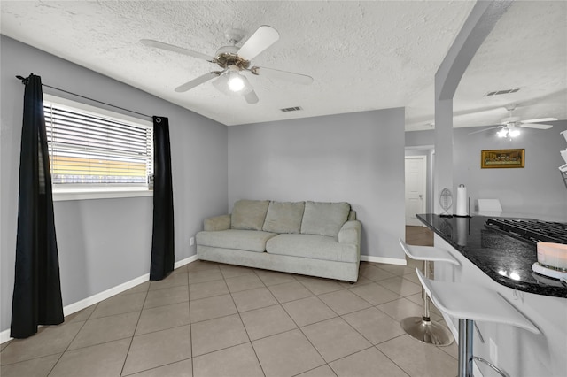 living room featuring a textured ceiling and light tile patterned flooring