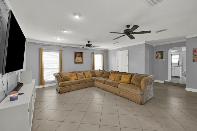 living room with light tile patterned floors, plenty of natural light, and ornamental molding