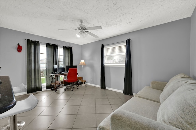 home office featuring light tile patterned floors, a textured ceiling, and ceiling fan