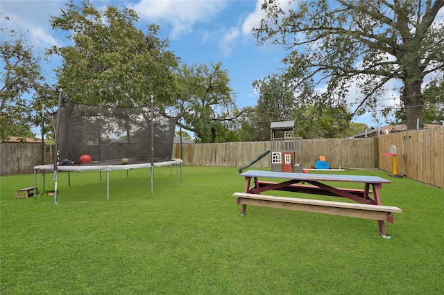 view of yard with a playground and a trampoline