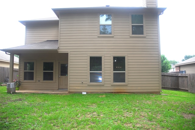 rear view of house with a yard and a patio area