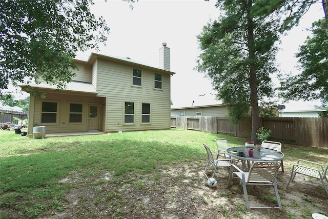 rear view of house featuring a yard