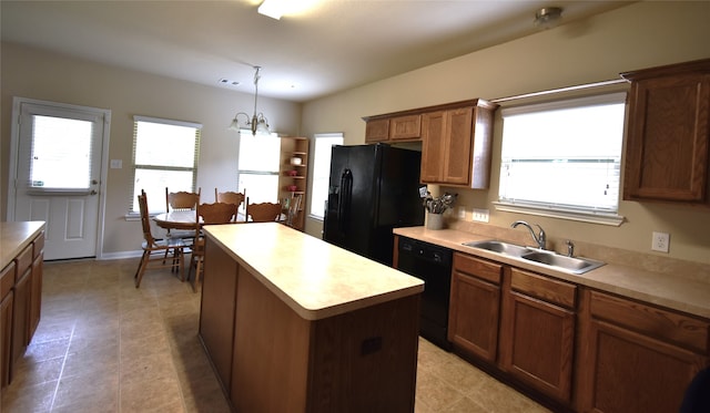 kitchen featuring sink, black appliances, pendant lighting, a notable chandelier, and a kitchen island