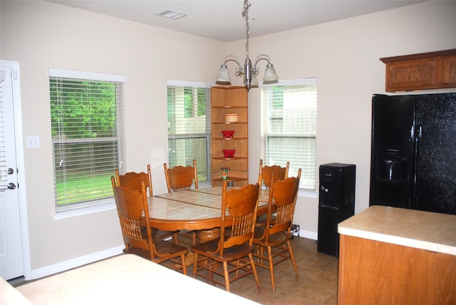 dining space featuring light tile patterned floors and an inviting chandelier