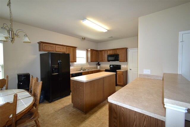 kitchen featuring a center island, an inviting chandelier, black appliances, sink, and kitchen peninsula