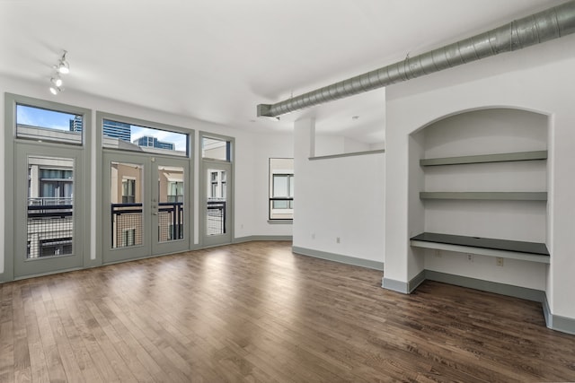 unfurnished living room featuring french doors, dark hardwood / wood-style flooring, and built in features