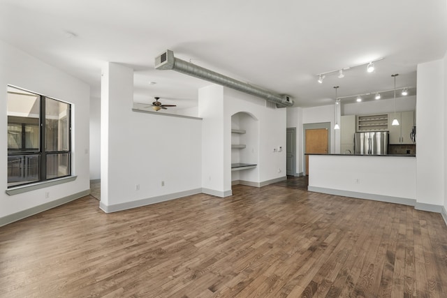 unfurnished living room with ceiling fan, dark hardwood / wood-style flooring, and built in features