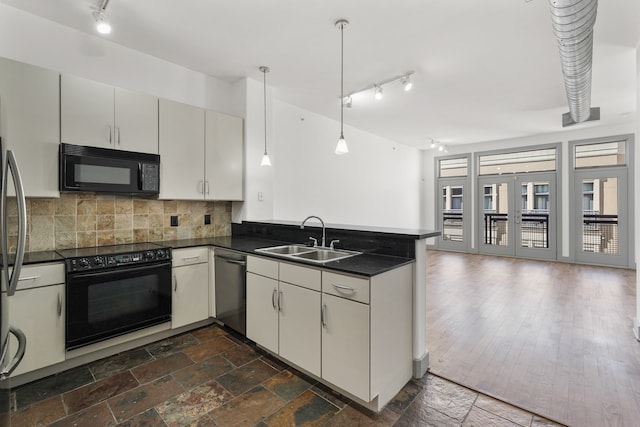 kitchen with black appliances, sink, dark hardwood / wood-style floors, decorative light fixtures, and kitchen peninsula