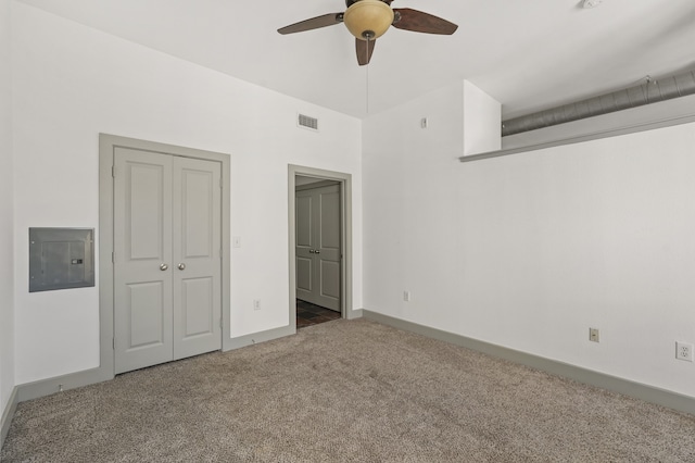 unfurnished bedroom featuring electric panel, ceiling fan, a closet, and carpet floors