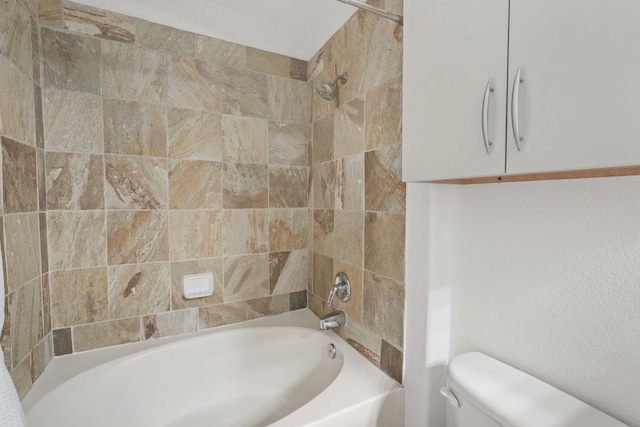 bathroom featuring tiled shower / bath combo and toilet