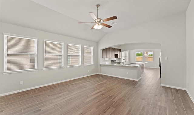 interior space featuring ceiling fan, sink, vaulted ceiling, and hardwood / wood-style flooring