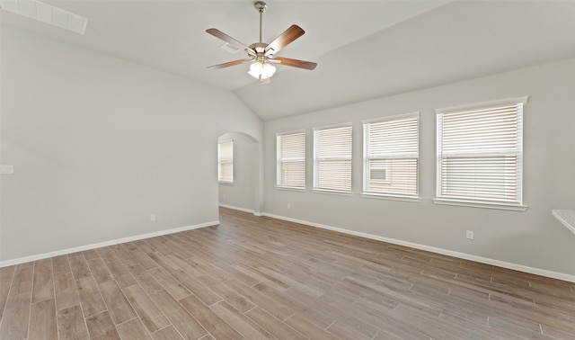 empty room with light wood-type flooring, plenty of natural light, lofted ceiling, and ceiling fan