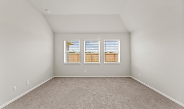 unfurnished room featuring light colored carpet and lofted ceiling