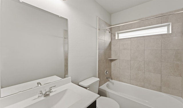 full bathroom with tiled shower / bath combo, toilet, and vanity