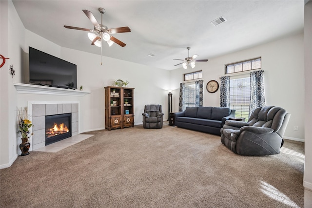 living room featuring ceiling fan, light carpet, and a fireplace