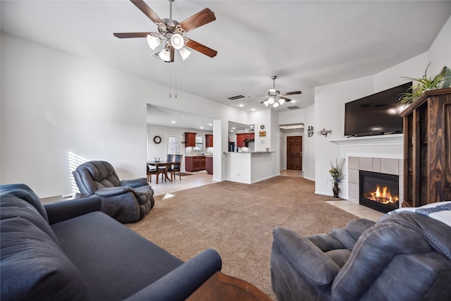 living room with light carpet, ceiling fan, and a fireplace