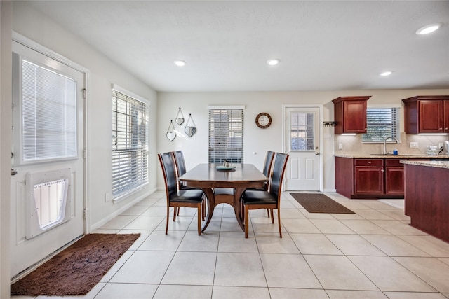 tiled dining space featuring heating unit and sink