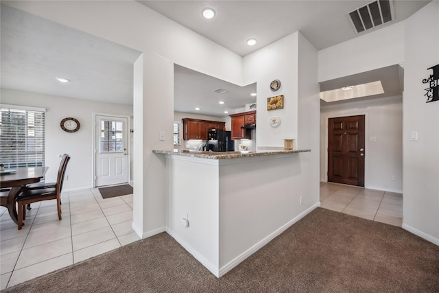 kitchen featuring light carpet, kitchen peninsula, black fridge with ice dispenser, and light stone countertops