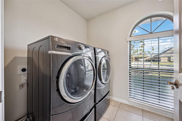 laundry area with separate washer and dryer and light tile patterned flooring