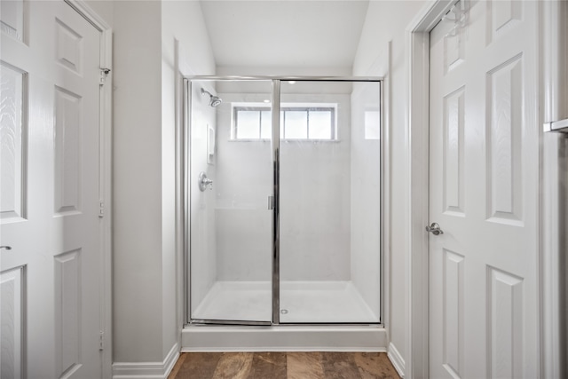 bathroom with vaulted ceiling and a shower with door