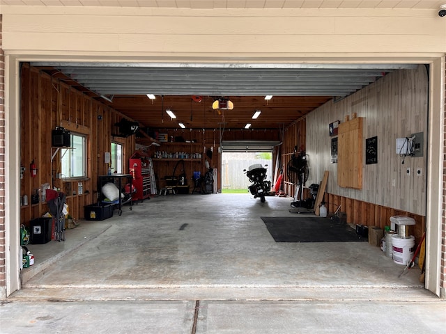 garage with a garage door opener and wood walls