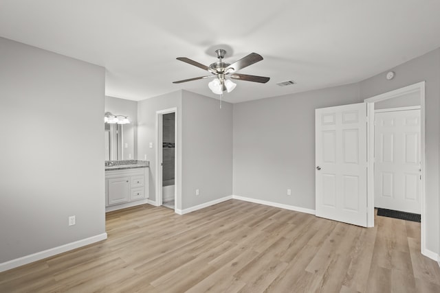 unfurnished bedroom with ceiling fan, light wood-type flooring, connected bathroom, and a closet