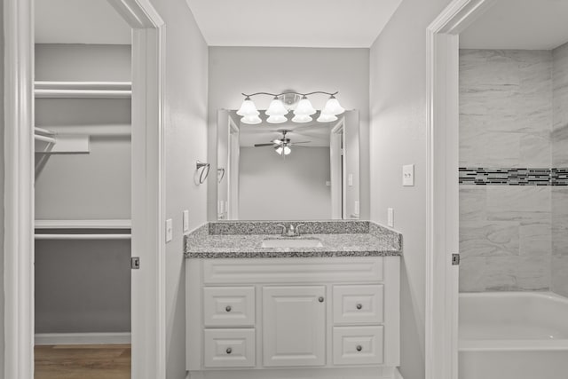 bathroom with wood-type flooring, vanity, and ceiling fan