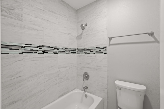 bathroom with tiled shower / bath combo and toilet