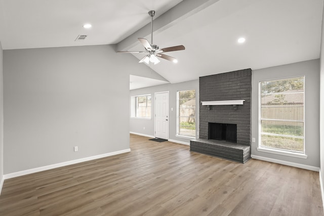 unfurnished living room with hardwood / wood-style flooring, vaulted ceiling with beams, ceiling fan, and a brick fireplace