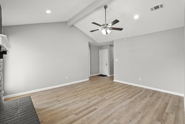 unfurnished bedroom with a brick fireplace, vaulted ceiling with beams, ceiling fan, and light hardwood / wood-style flooring