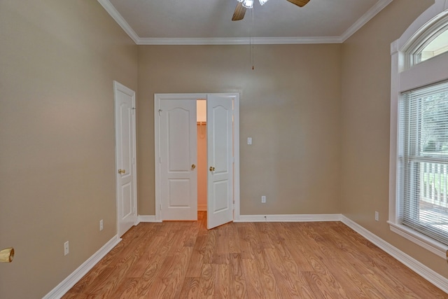 interior space featuring ceiling fan, ornamental molding, and light wood-type flooring