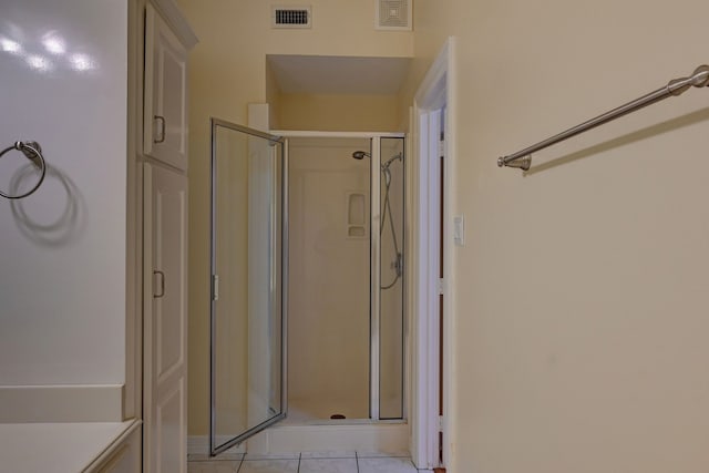 bathroom with tile patterned floors and a shower with shower door