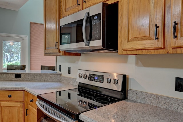 kitchen with light stone counters and stainless steel appliances