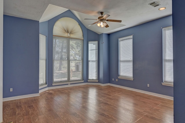 unfurnished room with a textured ceiling, hardwood / wood-style flooring, ceiling fan, and lofted ceiling