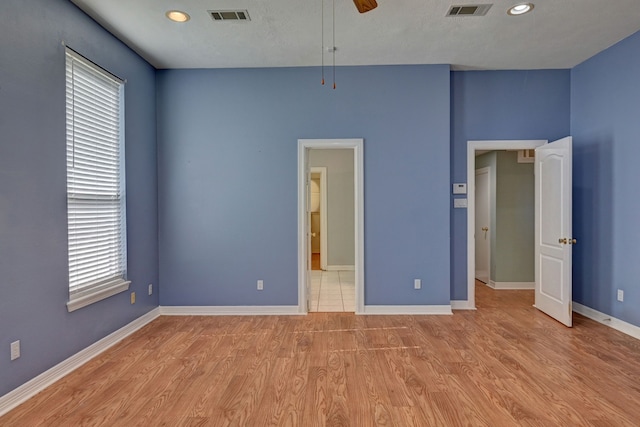 unfurnished bedroom featuring ceiling fan, light wood-type flooring, and a textured ceiling