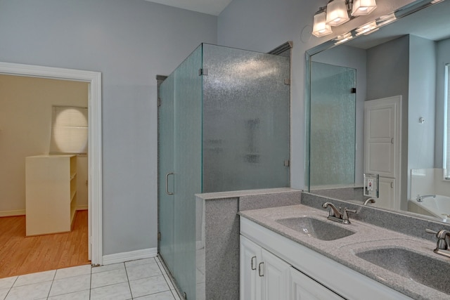 bathroom with hardwood / wood-style floors, vanity, and an enclosed shower