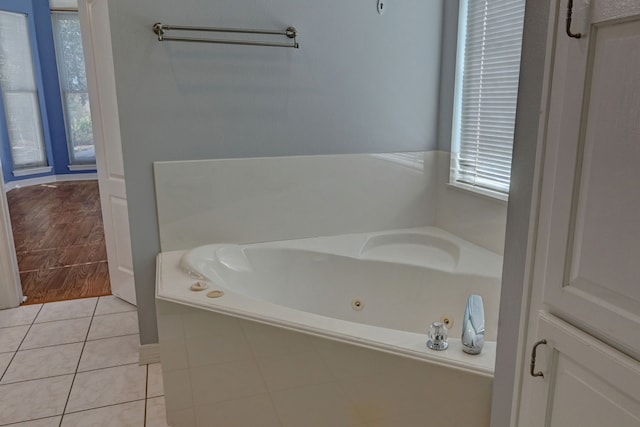 bathroom featuring tile patterned floors and a relaxing tiled tub