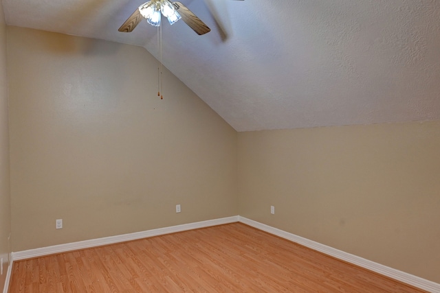 additional living space featuring a textured ceiling, light hardwood / wood-style floors, ceiling fan, and lofted ceiling