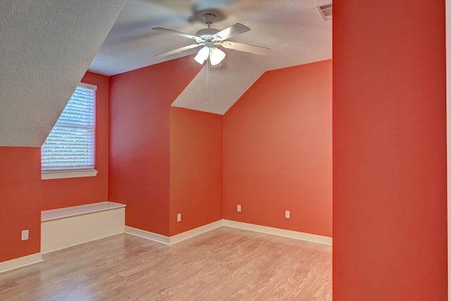 bonus room with a textured ceiling, light hardwood / wood-style flooring, and lofted ceiling