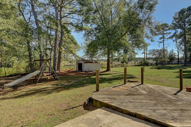 view of yard featuring a playground, a deck, and a storage shed