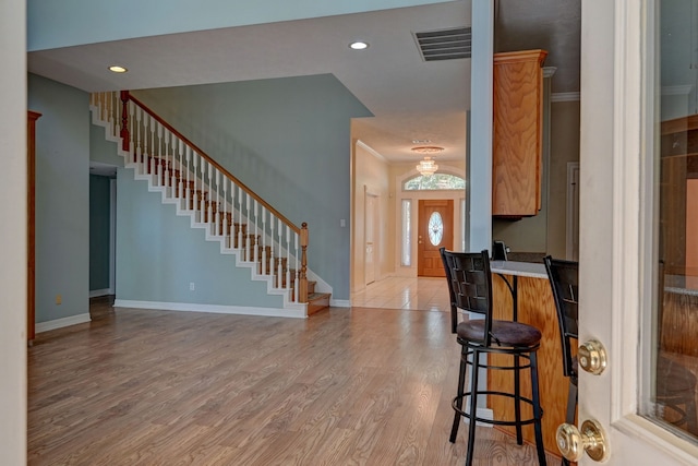 foyer with light hardwood / wood-style flooring and crown molding