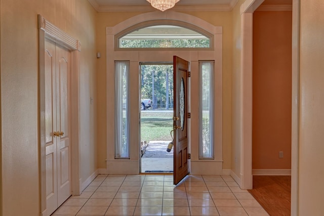 tiled entrance foyer with a healthy amount of sunlight and ornamental molding