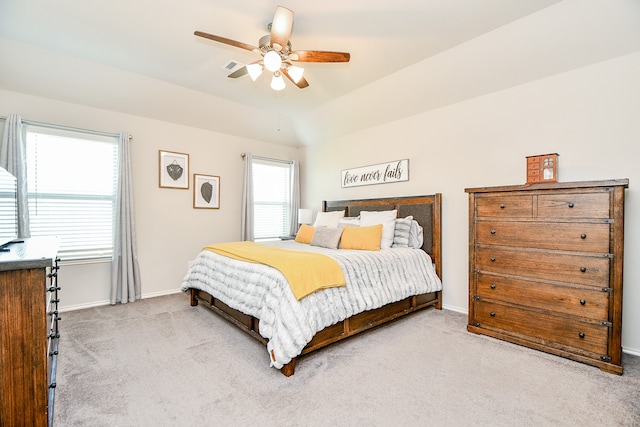 carpeted bedroom with multiple windows, ceiling fan, and vaulted ceiling